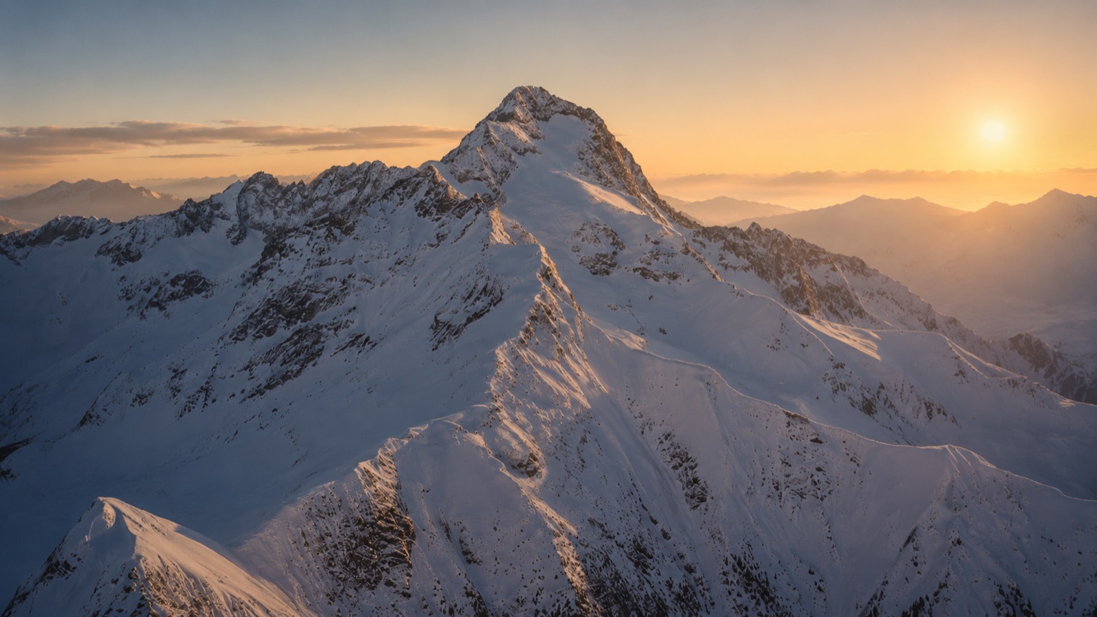Sommet alpin enneigé au lever du soleil, photographié au drone.